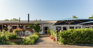 Eingang zu Kläsles Restaurant mit vielen Blumen.